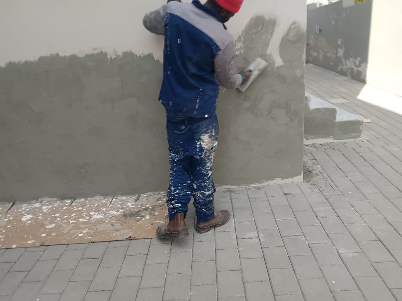 worker plastring wall during crack repairs